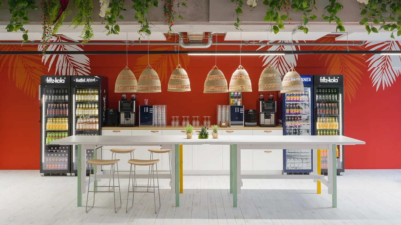 Die Bar: Palmen-Wand in Rot, Bast-Lampen, Kaffee & Kaltgetränke