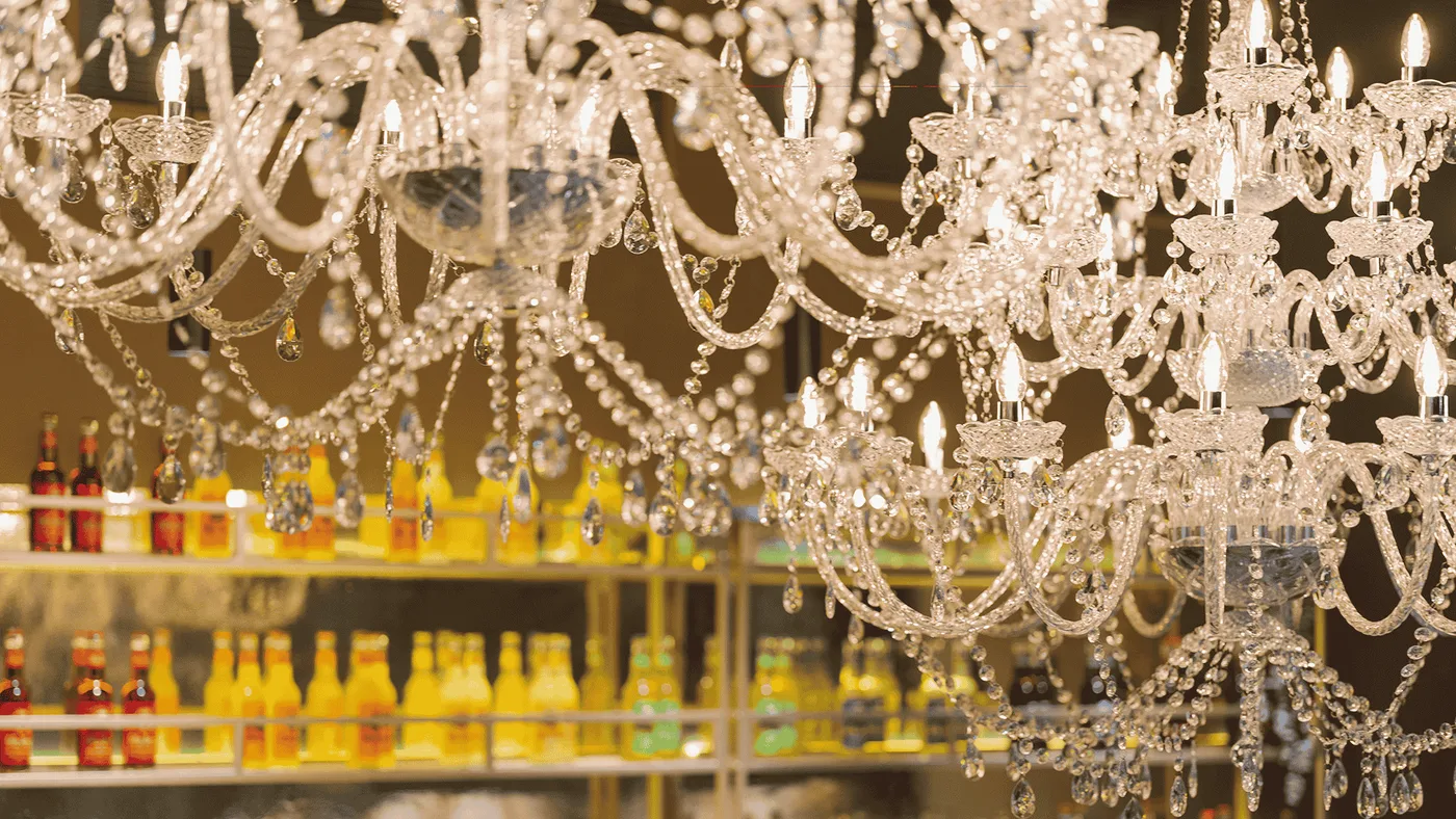 Kristall-Kronleuchter über der Bar — dahinter das goldene Flaschenregal