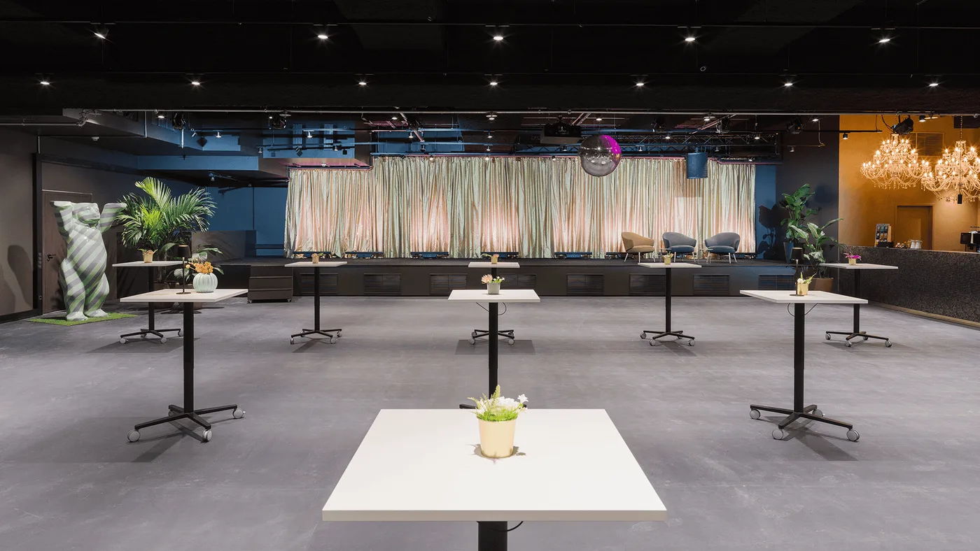 Stehtisch-Setup frontal zur Bühne — Empfang & Networking