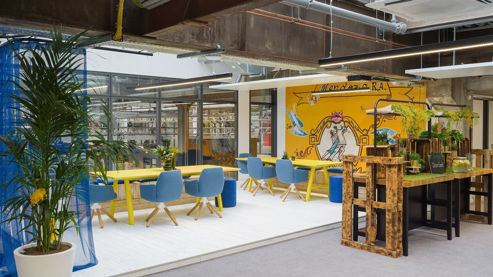 Innovativer Arbeitsbereich mit farbenfrohen Möbeln und urbanem Industriecharme im Smartvillage Köln-Mülheim