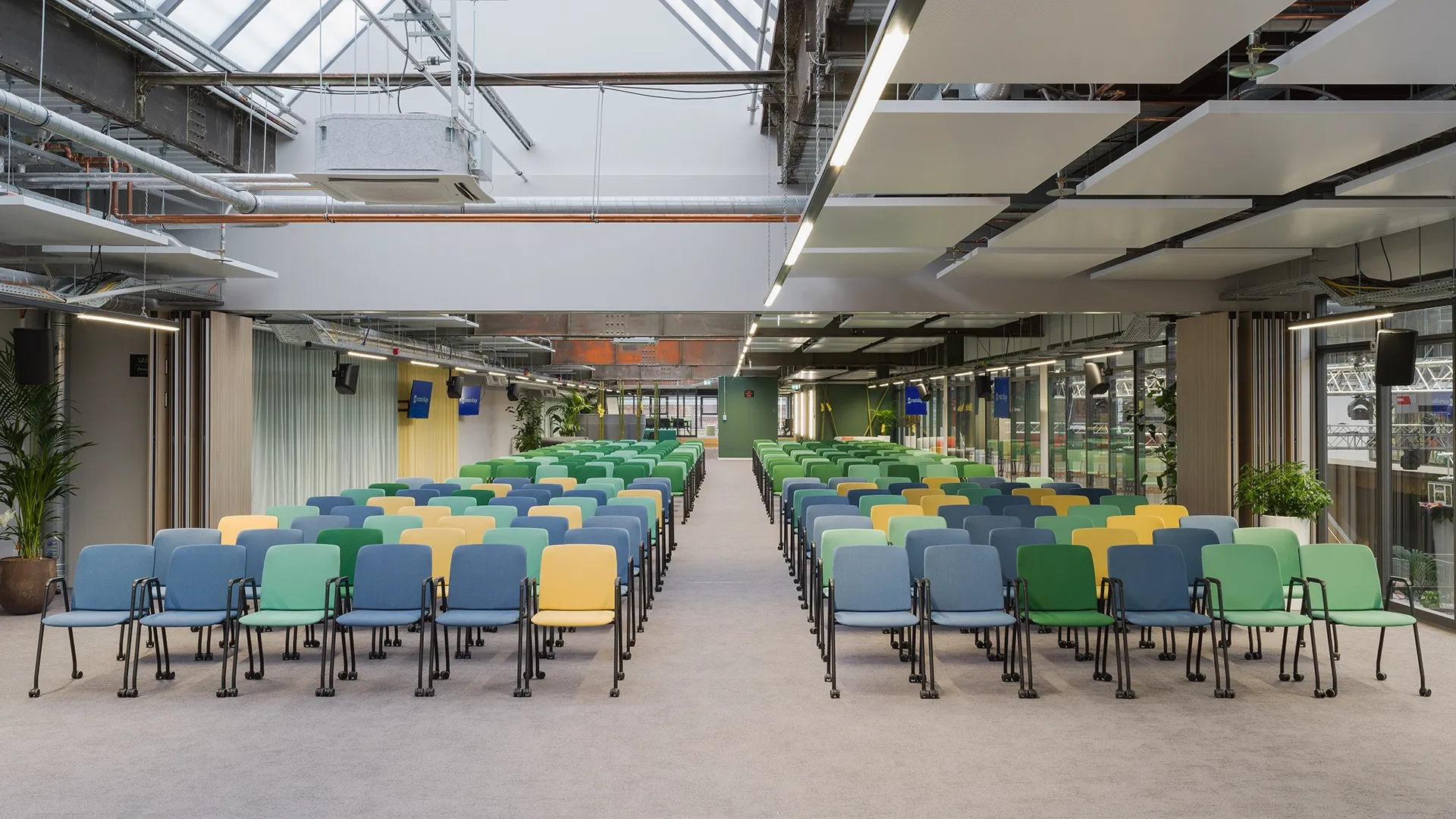 Großer Eventraum mit farbigen Stuhlreihen für Konferenzen oder Vorträge im Smartvillage Köln-Mülheim
