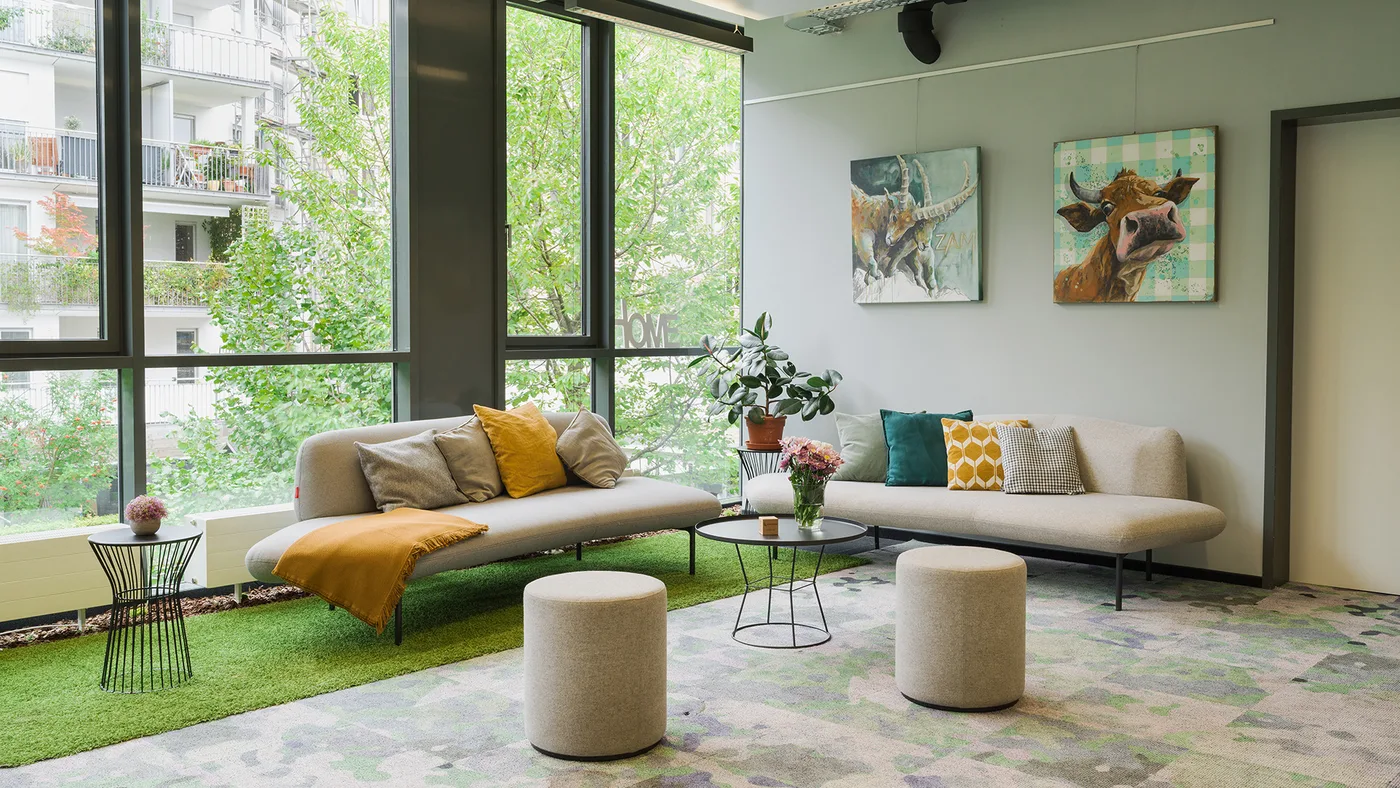 Lounge mit Sofas und Alpen-Portraits: Steinbock trifft Kuh